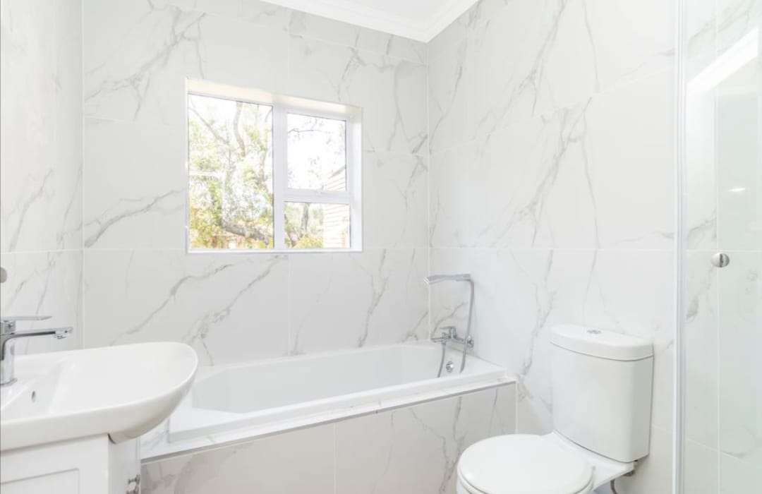 Completed bathroom with vanity, toilet and fitted bath area