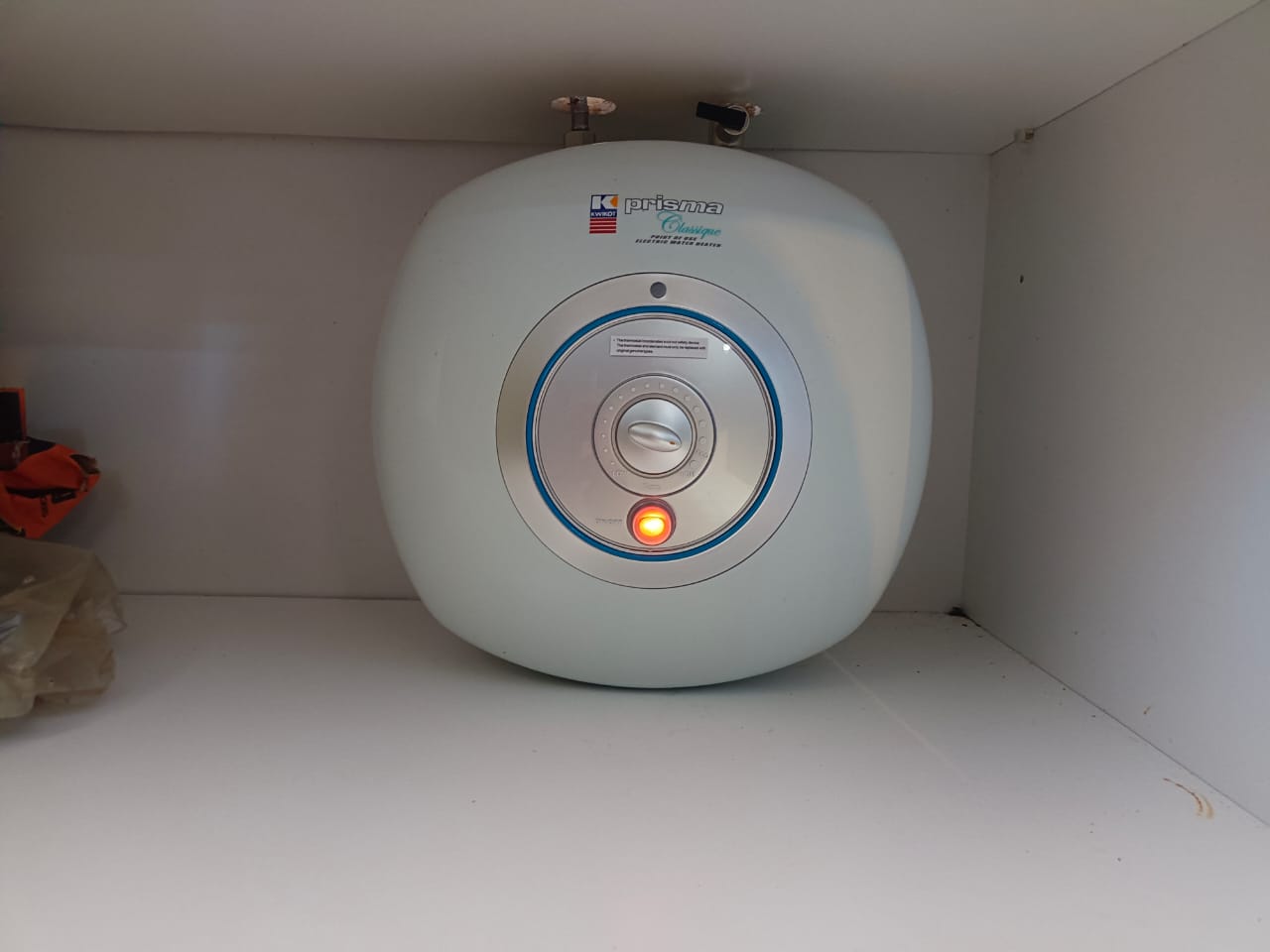 Compact under-counter geyser installed neatly inside a white cabinet